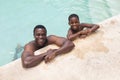 High angle portrait of african american happy shirtless father and son in swimming pool Royalty Free Stock Photo