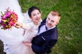 High angle portrait of cheerful wedding couple standing on grassy field Royalty Free Stock Photo