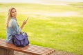 High angle portrait of smiling woman sitting on bench while holding smartphone Royalty Free Stock Photo
