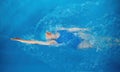 High angle of professional sportswoman swimming in backstroke