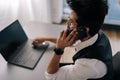 High-angle rear view of Indian bearded business man in glasses working at laptop sitting at desk and talking on Royalty Free Stock Photo