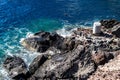 High angle of the rocks on the beach covered with rashing blue waves in Santorini Island, Greece Royalty Free Stock Photo