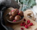 High angle selective focus shot of delicious chocoalte balls with raspberries on a wooden surface Royalty Free Stock Photo