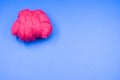 High angle shot of a ball of pink yarn on a blue surface Royalty Free Stock Photo