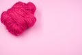 High angle shot of a ball of pink yarn on a pink surface Royalty Free Stock Photo