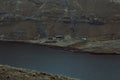 High angle shot of barn near a river  with rocky hill background Royalty Free Stock Photo