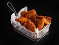 High angle shot of a basket of delicious fried chicken on a black background