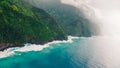 High angle shot of the beautiful foggy cliffs over the calm blue ocean captured in Kauai, Hawaii Royalty Free Stock Photo