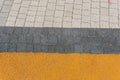 High angle shot of a beautiful pathway with grey and white tiles and a yellow line Royalty Free Stock Photo