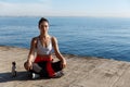 High angle shot of beautiful relaxed woman having yoga training near the sea, meditating on a pier Royalty Free Stock Photo