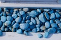 High angle shot of blue small pebbles on the white colored wood Royalty Free Stock Photo