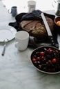 High-angle shot of a bowl of cherries and a freshly baked bread in the kitchen