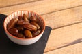 High angle shot of a bowl of Moroccan dates on a wooden surface