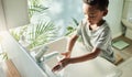 Kids should wash their hands often with soap and water. High angle shot of a boy washing his hands at a tap in a Royalty Free Stock Photo