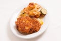 High angle shot of breaded pork cutlet with tomato bake casserole, zucchini and potato Royalty Free Stock Photo