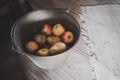 High-angle shot of a bucket full of fresh organic apples and pears in a dusty wooden shack