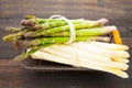 High angle shot of a bundle of green asparagus and white asparagus on a wooden table