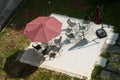 High angle shot of chairs and tables under an umbrella in a green park Royalty Free Stock Photo