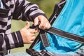 High angle shot of a child fixing his blue car seat captured on a sunny day