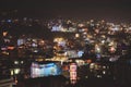 High angle shot of city buildings with lit lights at night time Royalty Free Stock Photo