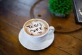 High angle shot of coffee with the words Togo Cafe and hearts on it put on a wooden table