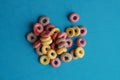 High angle shot of colorful fruit loops isolated on a blue surface Royalty Free Stock Photo