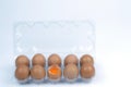 Top view of cracked fresh egg and whole eggs with bright yolk in plastic tray for eggs. Royalty Free Stock Photo