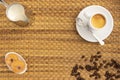 High angle shot of a cup of coffee, milk, donuts, and coffee beans on a woven surface Royalty Free Stock Photo