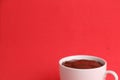 High angle shot of a cup of hot chocolate isolated on a red surface Royalty Free Stock Photo