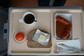 High angle shot of a cup of tea with bread, butter, egg and sausage in a tray Royalty Free Stock Photo