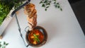 High angle shot of a delicious barbeque hanging over a bowl of soup