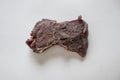 High angle shot of a delicious piece of beef jerky on a white surface
