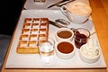 High angle shot of a delicious waffle with a cup of cappuccino and other delicious desserts Royalty Free Stock Photo