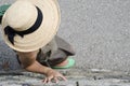 High angle shot of a female with straw hat and green shoes leaning on the wall