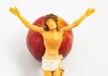 High angle shot of a figurine of Jesus laid on the top of a red apple