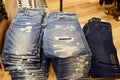 High angle shot of folded faded ripped jeans on a store shelf