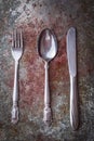 High angle shot of a fork, knife, and a spoon on a table Royalty Free Stock Photo