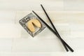 High angle shot of a fortune cookie on a plate and two black chopsticks on a wooden surface Royalty Free Stock Photo