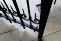 High angle shot of a fragment of a decorative metal gate with a tile ground on the background