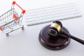 High angle shot of a gavel, a keyboard, and a miniature cart on a white surface Royalty Free Stock Photo