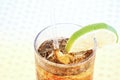 High angle shot of a glass of cold coke with a lemon slice on white background