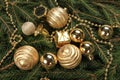 High angle shot of golden baubles with string beads on fir branches