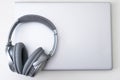 High angle shot of a gray headphone on a gray laptop isolated on a white background Royalty Free Stock Photo