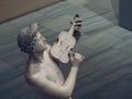 High angle shot of a grey statue of a male playing the violin Royalty Free Stock Photo