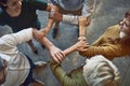 Behind a successful business is a strong team. High angle shot of a group of colleagues linking arms in solidarity at