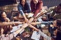 Food inspires everyone. High angle shot of a group of creative workers piling their hands while out on a business lunch.