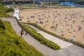 High angle shot of a group of friends waving hands on the background of a crowded beach