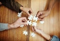 Putting the pieces together. High angle shot of a group of unrecognizable university students building a puzzle while