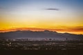 High-angle shot of Las Vegas skyline at sunset, mountain silhouettes, purple, golden sky background