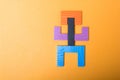 High angle shot of a man formed by pentomino puzzle isolated on orange background Royalty Free Stock Photo